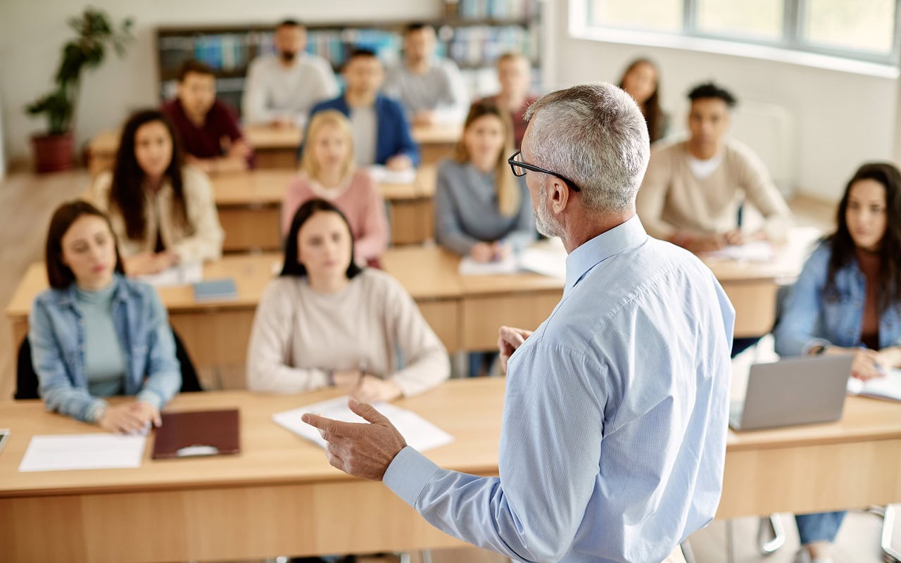 A man is giving a lecture to a group of people.