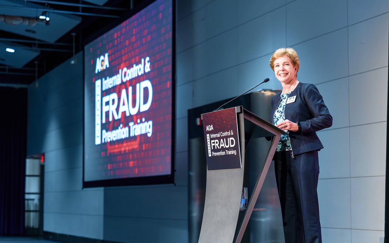Ann Ebberts stands at the podium at Internal Control & Fraud Prevention Training 2024