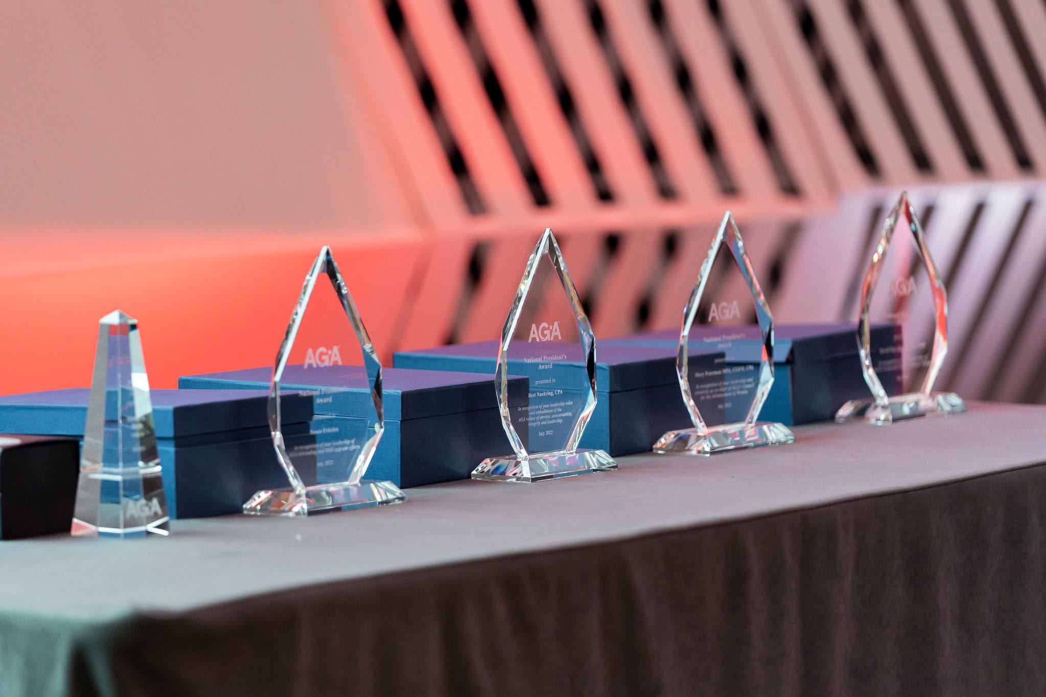 A row of engraved crystal awards sit on a table