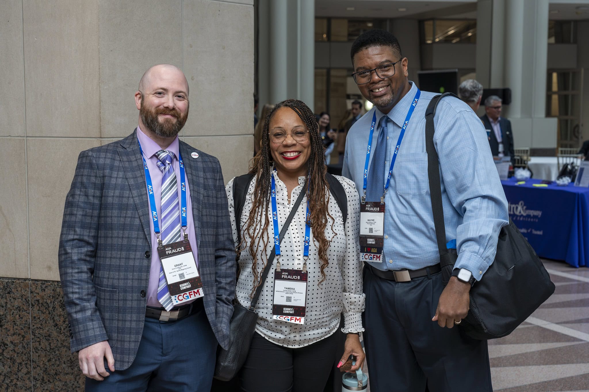 Three AGA members stand shoulder to shoulder in the Solutions Hall at Fraud 2024.